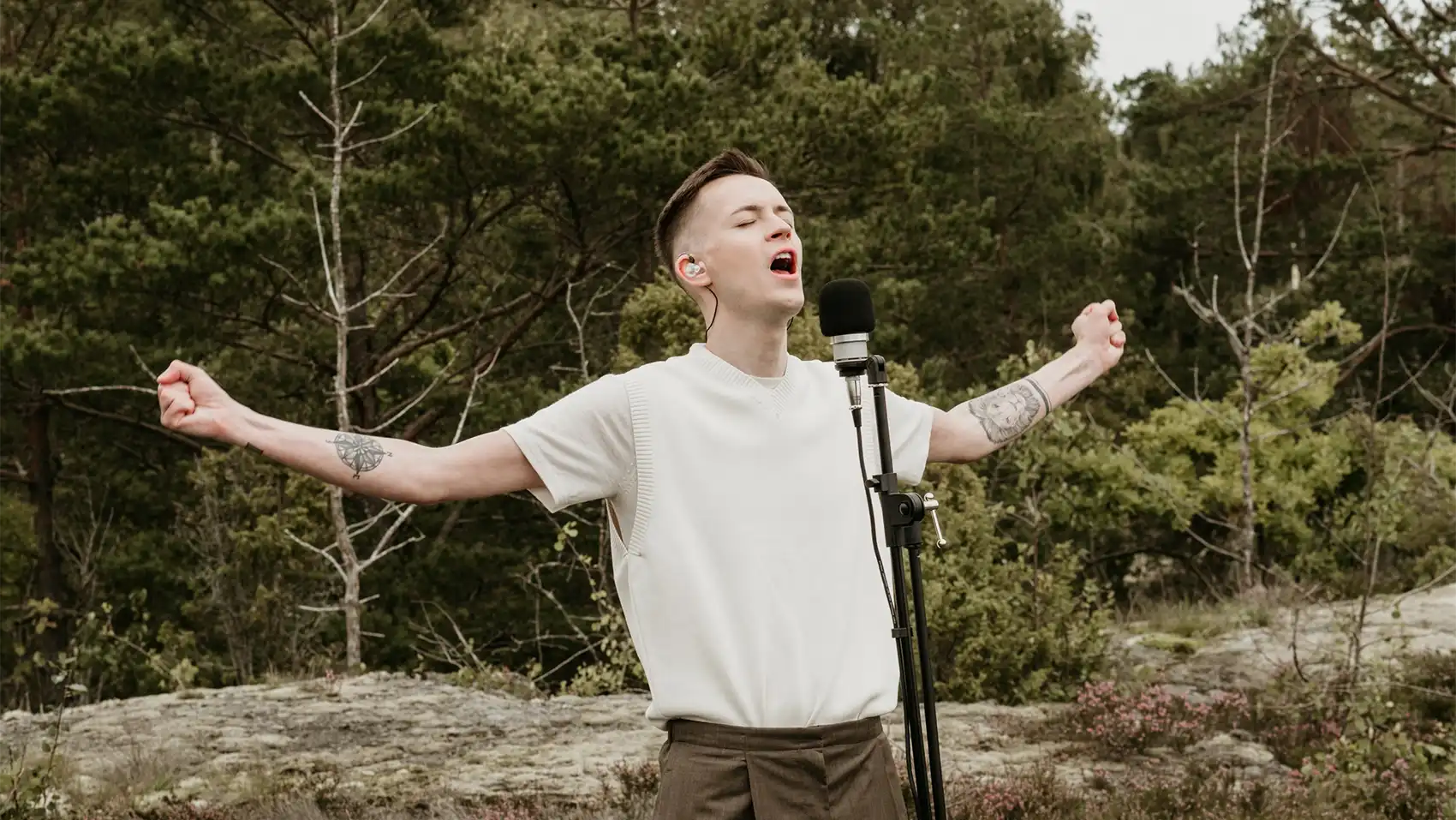 EliotXII extending his arms wide open while singing live